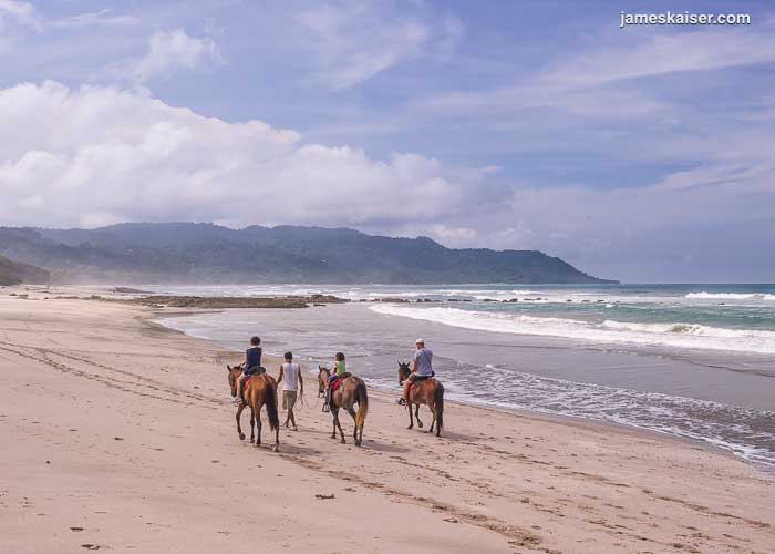 Horseback riders on Santa Teresa beach, Costa Rica